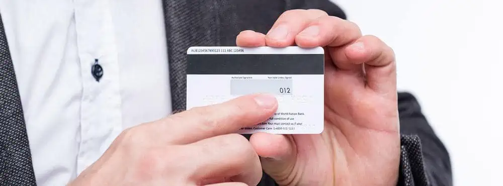 man showing where CVV is located on a credit card